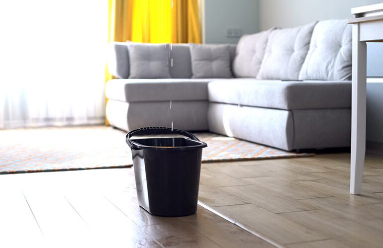 Water leaking through roof into bucket of living room