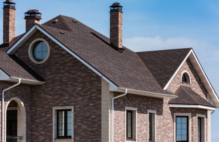chimney on the roof of the house against the blue sky. Residential roofing for salt lake city and Ogden